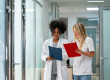 Deux professionnelles de santé consultent des dossiers médicaux dans un établissement de soins, illustrant les opportunités d'emploi médical et le travail en équipe.