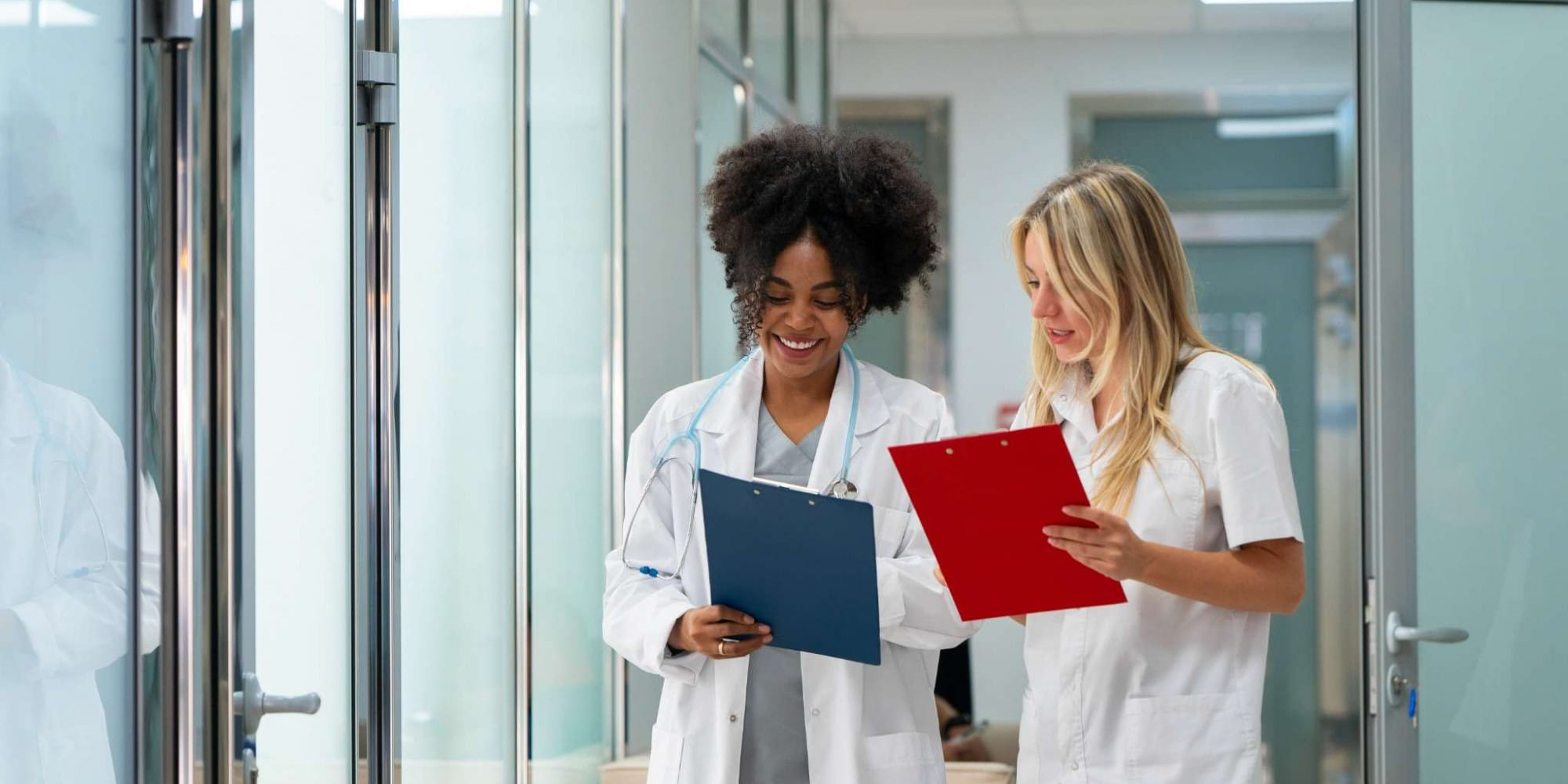 Emploi médical : des opportunités dans toute la Franceessee Deux professionnelles de santé consultent des dossiers médicaux dans un établissement de soins, illustrant les opportunités d'emploi médical et le travail en équipe.