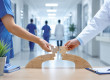 Une infirmière et un médecin assemblent les dernières pièces d'un pont en puzzle dans un couloir d'hôpital, symbolisant la continuité des soins et la transmission des compétences.